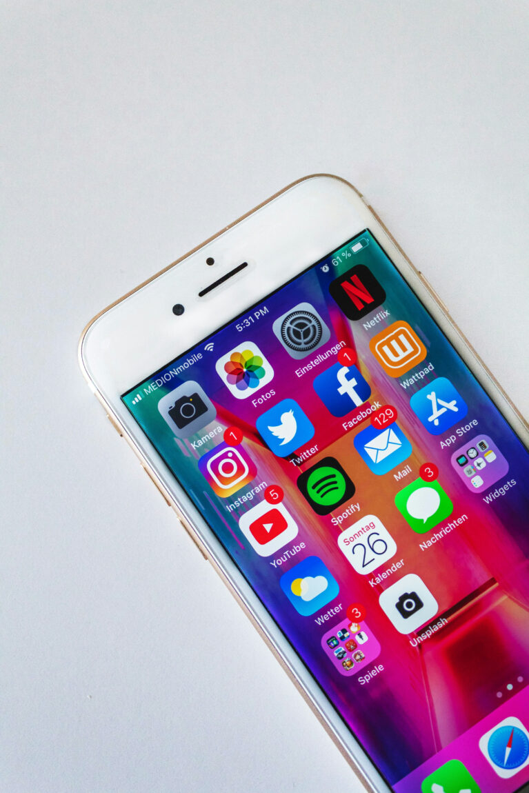 Smartphone displaying colorful social media apps and notifications on a vibrant, gradient background. Time shows 5:31 PM.